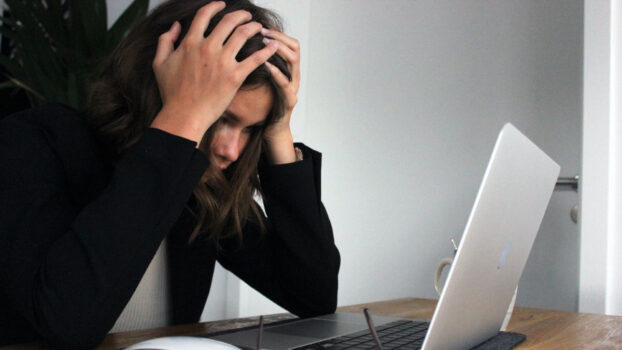 woman in front of her mac frustrated trying to understand why websites are blocked